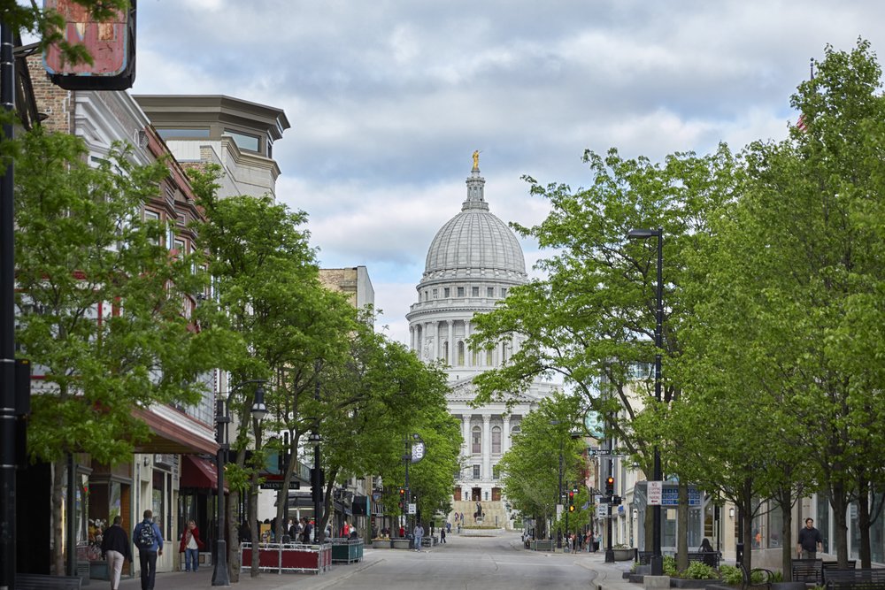 A street view a tree-lined street with the Capitol Lakes building in the background.